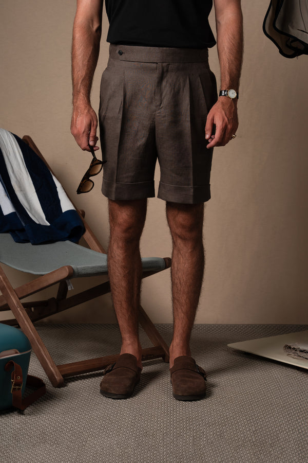 Nuestra bermuda en marrón chocolate&nbsp;es una obra de arte para el verano. Diseñada con doble pinza frontal, vuelta de 5 cm en el bajo y tensadores laterales funcionales, esta prenda toma elementos del pantalón clásico de sastrería y los adapta a una silueta más ligera, pensada para el verano.

Confeccionada en 100% lino&nbsp;en tono marrón chocolate lo que le aport ser profundamente versátil: funciona como neutro cálido para looks relajados de día, pero también eleva cualquier conjunto para las noches es